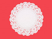 Fancy paper doily, round, perforated and embossed, on red