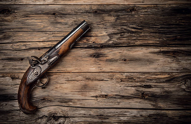 Old hand gun on wod Very old hand gun on wooden planks, shot from upper view old guns stock pictures, royalty-free photos & images