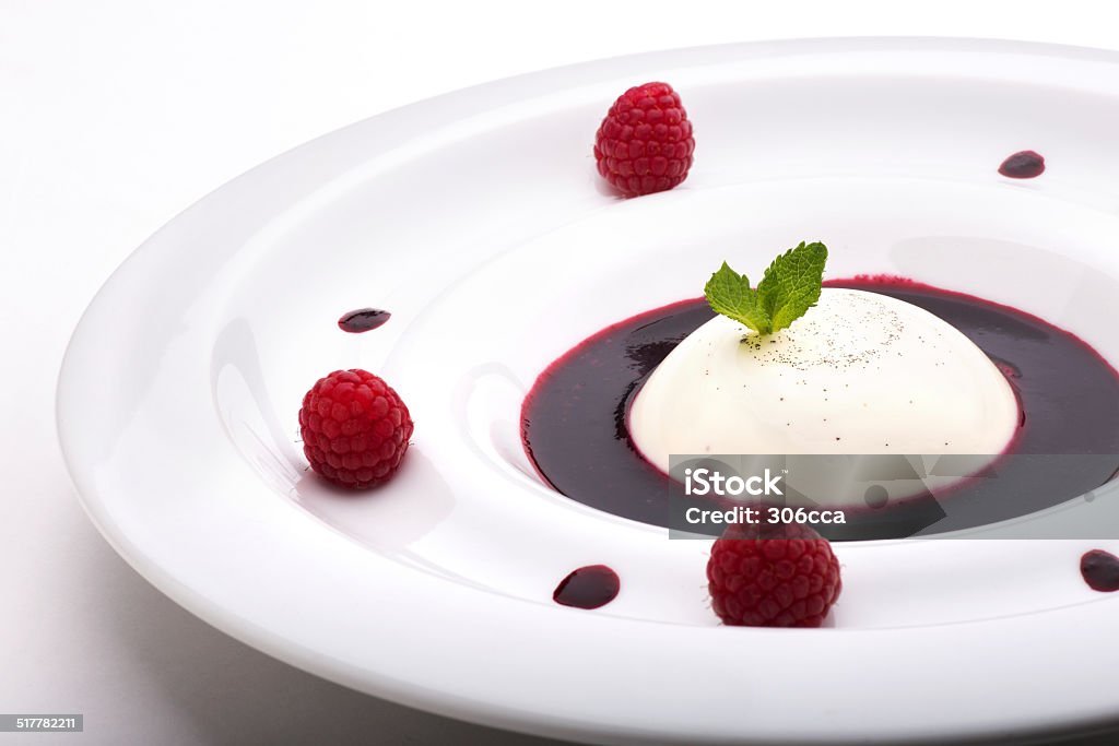 Panna cotta Panna cotta with fresh cream and cottage cheese with blueberry syrup decorated with mint leaves and raspberries. Cream - Dairy Product Stock Photo