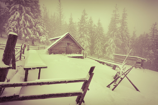 Old farm in the mountains at winter. Retro style.