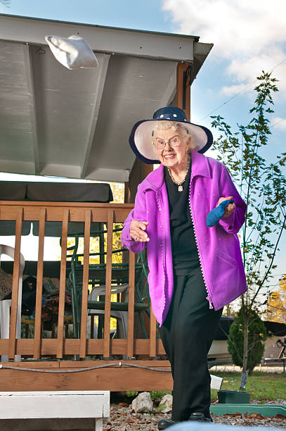 starsza kobieta gra cornhole - cornhole leisure games outdoors color image zdjęcia i obrazy z banku zdjęć