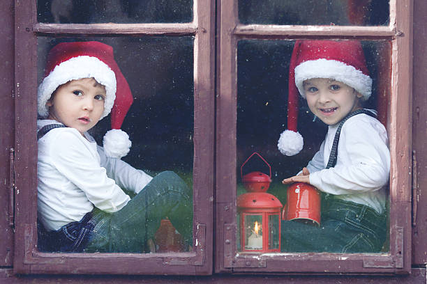 istock Two cute boys, looking through a window, waiting for Santa 517797497