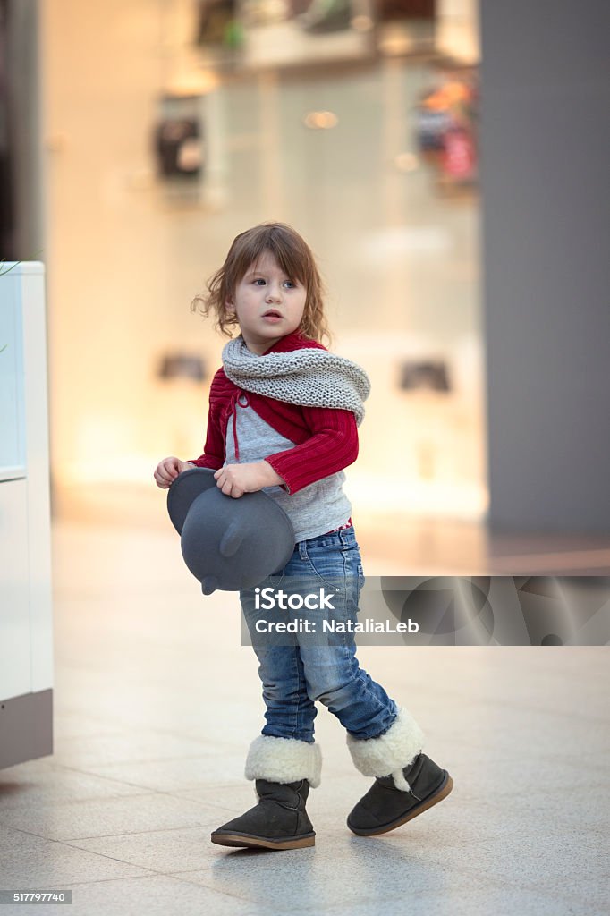 baby Girl in  red jacket black fedora hat, walk  mall thoughtful baby Girl in a red jacket  black fedora hat, walk the mall Activity Stock Photo