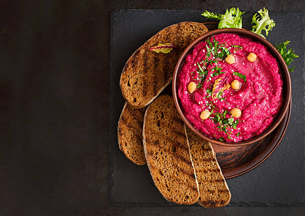 arrostito barbabietole hummus con pane tostato in una ciotola in ceramica - hummus foto e immagini stock