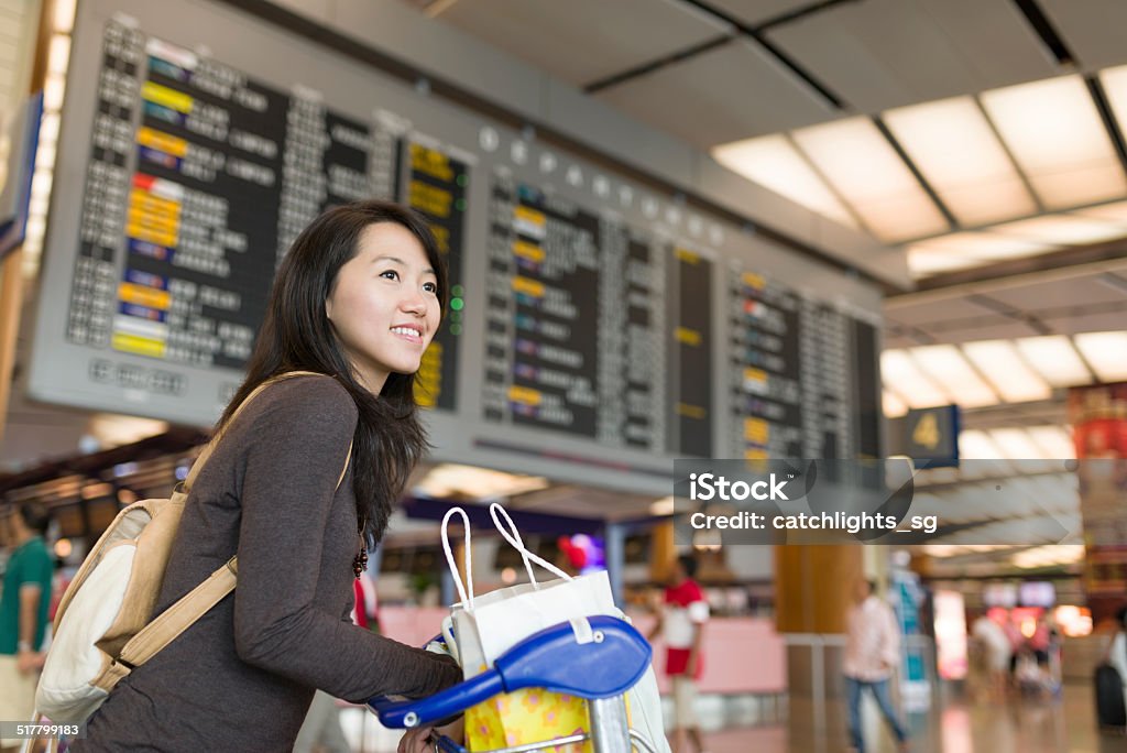 Young Asian woman pushing trolley Attractive young Asian woman pushing a luggage trolley Airport terminal. 25-29 Years Stock Photo