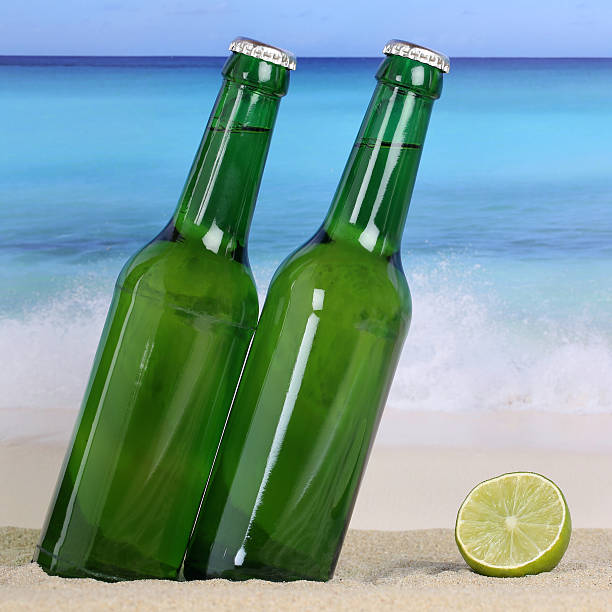 istock Beer bottles on the beach in sand 517799685
