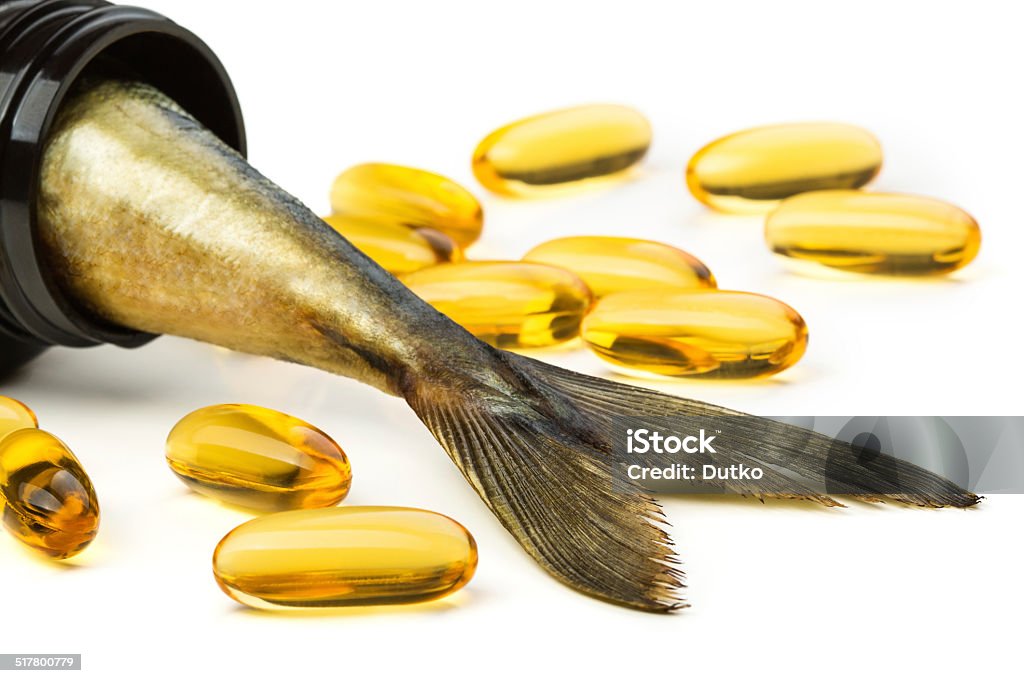 Cápsulas de aceite de pescado y pez cola en frasco marrón - Foto de stock de Aceite para cocinar libre de derechos