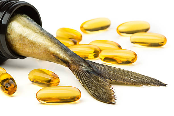 cápsulas de aceite de pescado y pez cola en frasco marrón - fish oil fotos fotografías e imágenes de stock