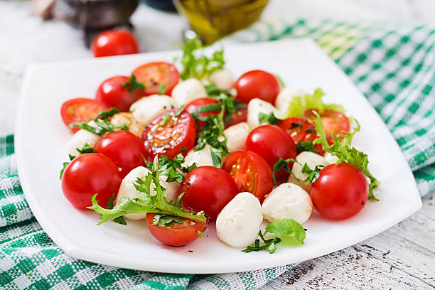 istock Caprese salad tomato and mozzarella with basil and herbs 517801078