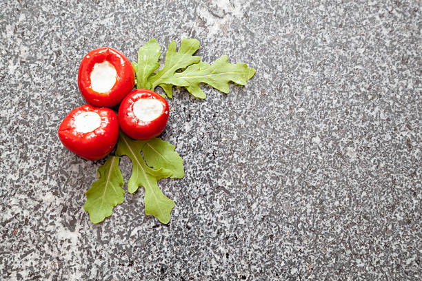 grey granite chopping board with stuffed peppers and rocket salad