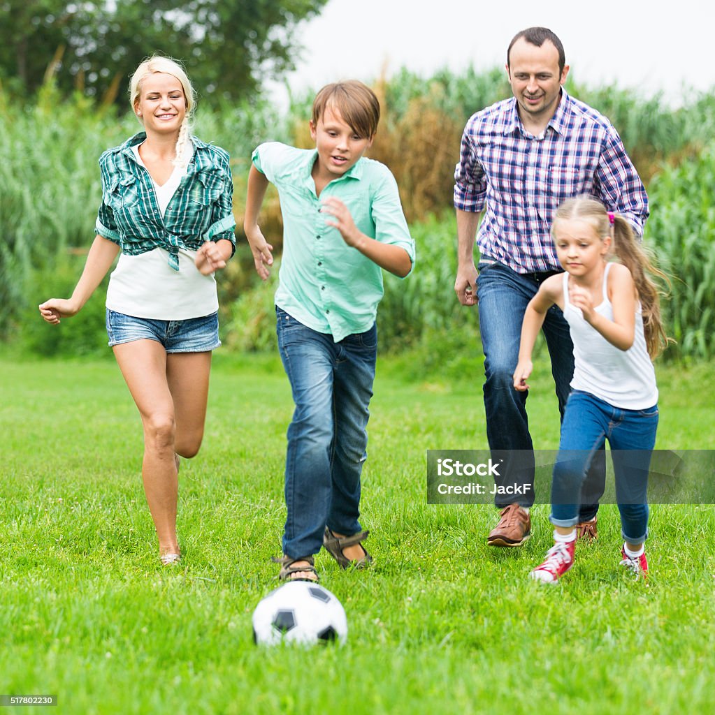 Foto de Descontraído Família De Quatro Pessoas Jogando Futebol e mais fotos  de stock de Adulto - iStock