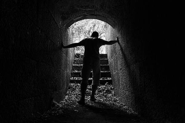 istock Young tired man leaves dark stone tunnel 517802476