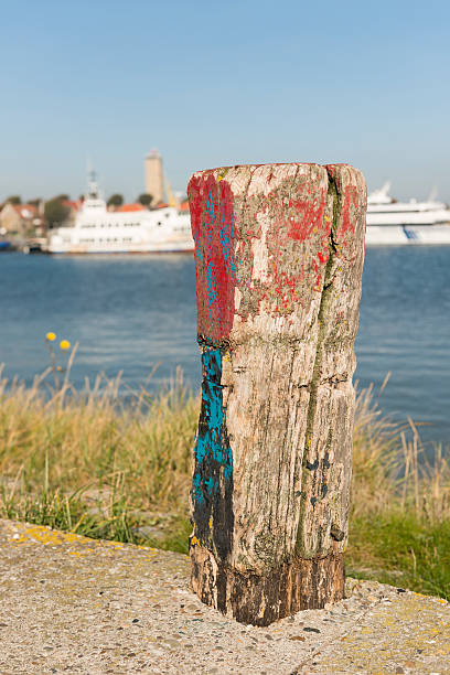 istock Old weathered and beautifully colored mooring pole. 517803482