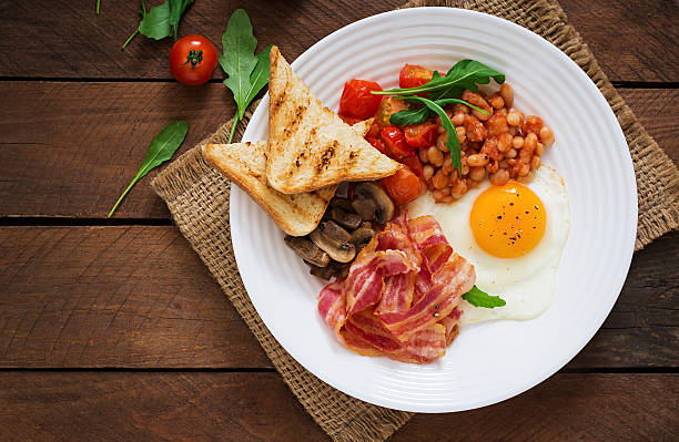 istock English breakfast - fried egg, beans, tomatoes, bacon and toast. 517803706