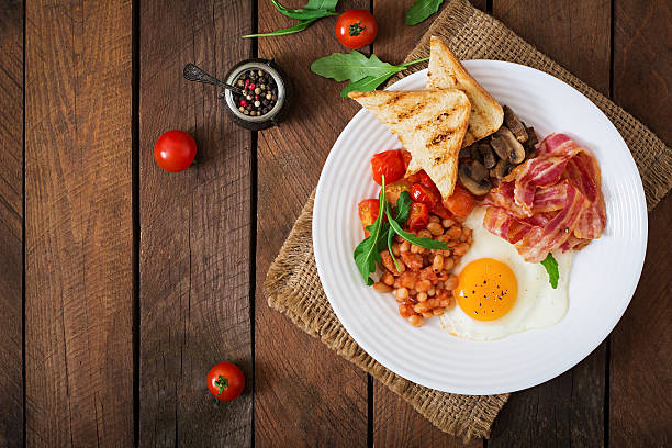 istock English breakfast - fried egg, beans, tomatoes, bacon and toast. 517803778