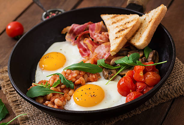 istock English breakfast - fried egg, beans, tomatoes, bacon and toast. 517804050