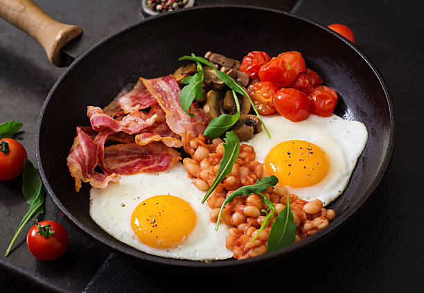 istock English breakfast - fried egg, beans, tomatoes, bacon and toast. 517804240