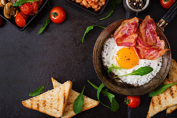 istock English breakfast - fried egg, beans, tomatoes, bacon and toast. 517804730