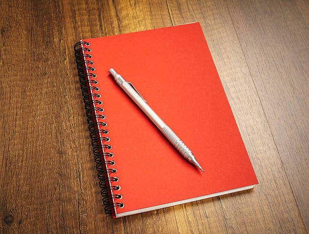 istock Note book with pencil on a wooden desk 517808656