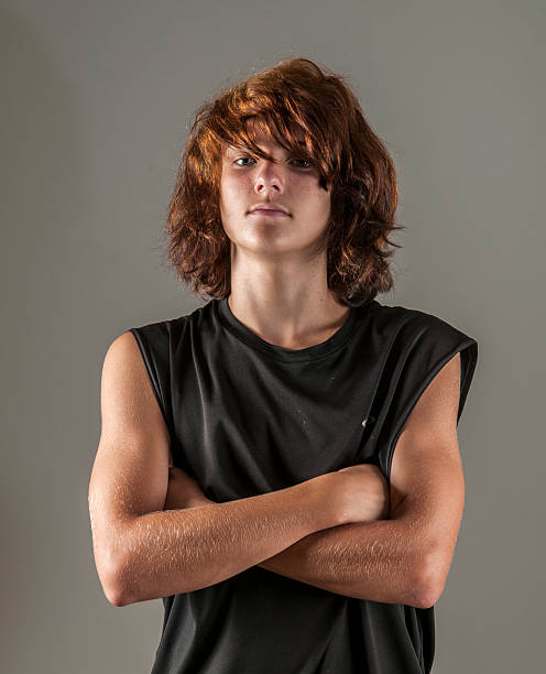 Handsome, strong teen boy, arms crossed, looking cool Handsome, athletic kid with long red, punk hair emo boy stock pictures, royalty-free photos & images