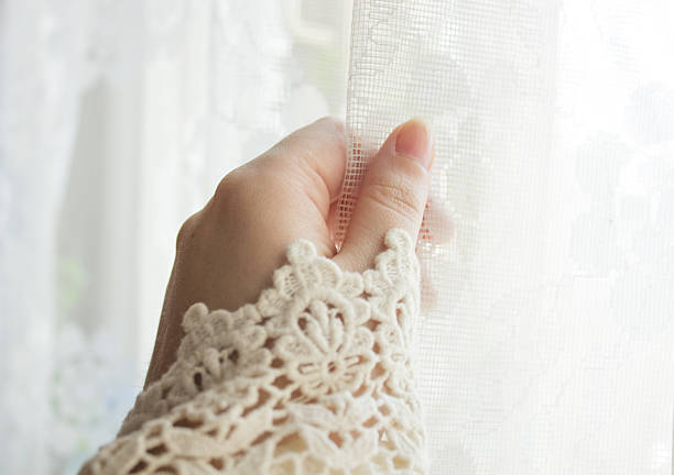 istock Female hand opening the curtain on the window 517810450