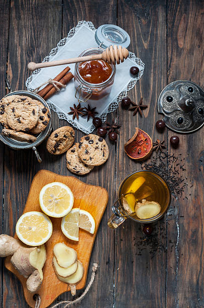 istock Dried tea with lemon and cookies on wooden table 517810662