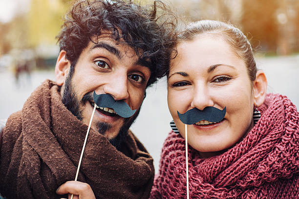 couple making selfie с mustaches - risible стоковые фото и изображения