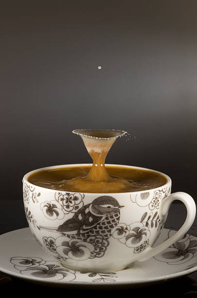 tasse à café avec goutte de lait landing dans le café - water surface emotional stress shape nature photos et images de collection