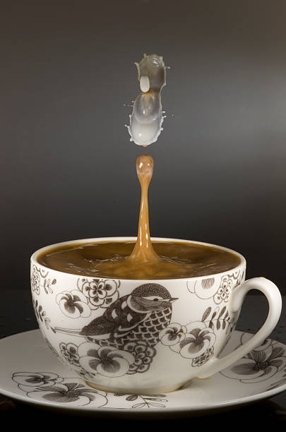 copo de café com gota de leite no café de aterragem - water surface emotional stress shape nature imagens e fotografias de stock