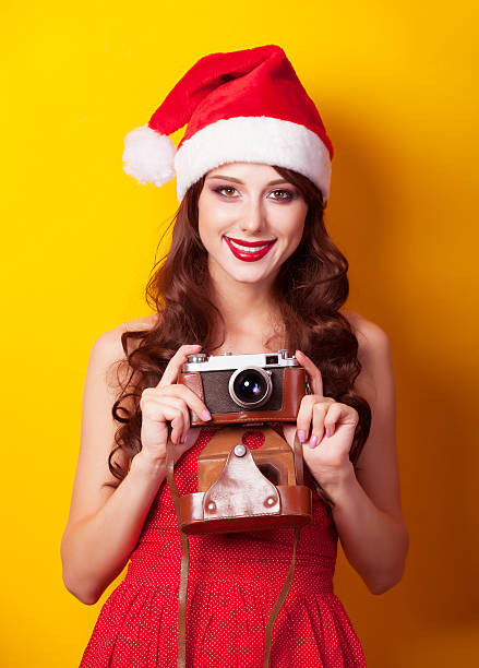 istock girl in christmas hat with camera 517813205