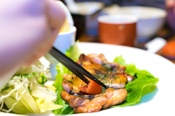 istock Hand Chopsticks Grilled Chicken with Egg and Salad 517814553