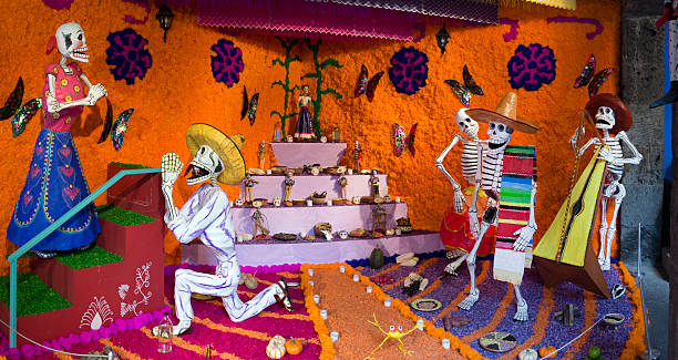 Day of the Dead skeletons in Mexico Mexico City, Mexico - October 31, 2012: Traditional Mexican life-size Dia de Muertos (Day of the Dead - All Saints) altar with sugar skulls and candles. The altar is made from paper mache and decorated with various grains and flowers. mexican day of the dead stock pictures, royalty-free photos & images