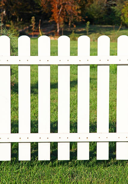 istock White fence on green grass. 517814617