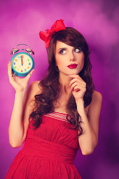 istock Surprised girl with alarm clock on violet background. 517816365