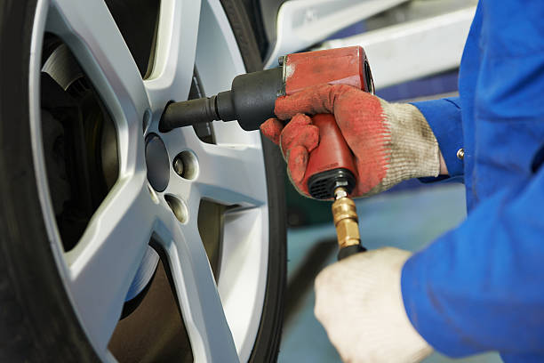 istock auto mechanic screwing car wheel 517818835