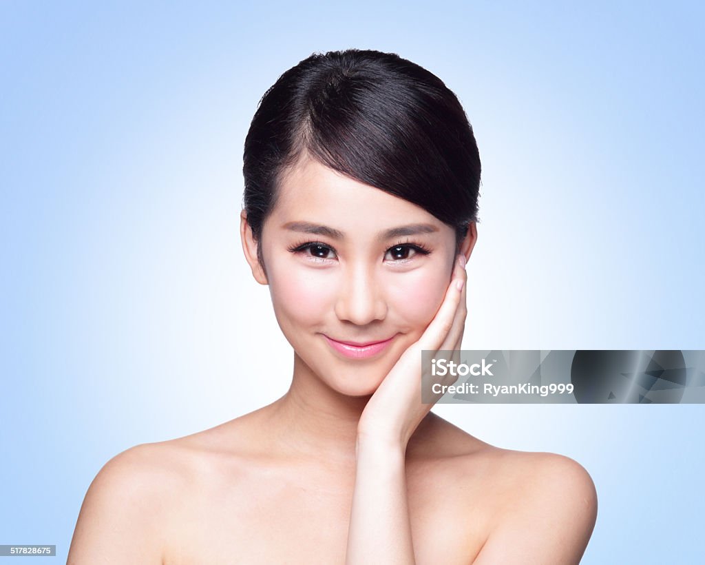 beautiful Skin care woman Face Beautiful Skin care woman Face smile to you isolated on blue background. asian Beauty Adult Stock Photo