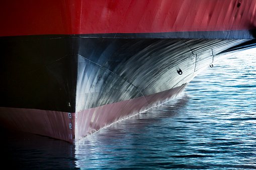 A beautifull horizontal graphic view of the bow of a large ship in port. It would make a great image forf anything involving international shipping; transportation; industrial cargo or ferry.