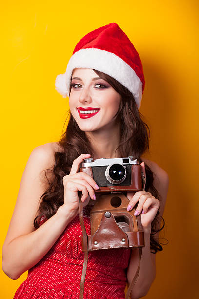 istock girl in christmas hat with camera 517831451