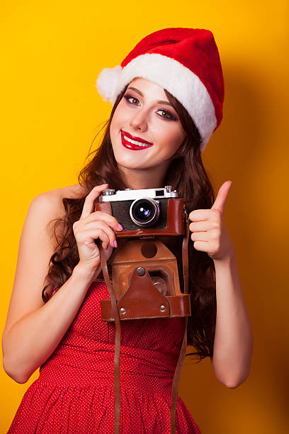 istock girl in christmas hat with camera 517831453