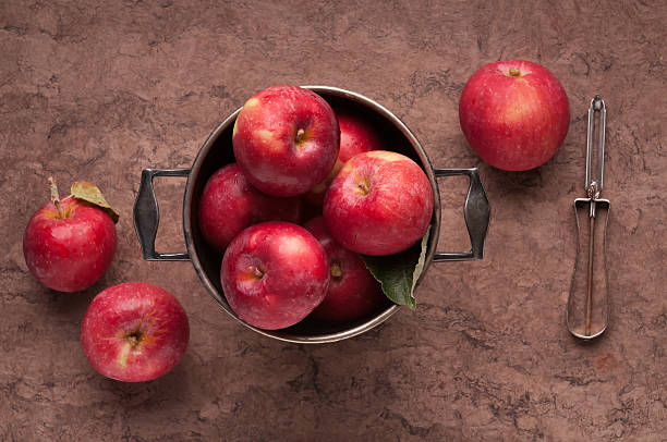 organiche mele in un secchio in argento con un vecchio sbucciatore - spartan apple foto e immagini stock