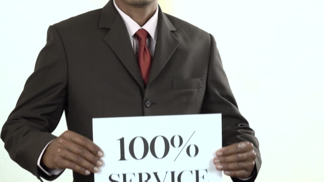 Businessman holding white card with 100% Service sign