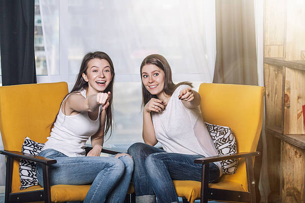dos hermosas mujeres amigos hablando de sonrisas felices en casa - twin tips fotografías e imágenes de stock