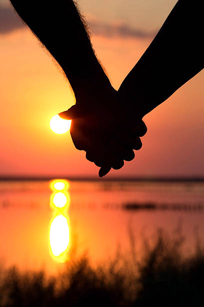 istock silhouette of couple at sunset holding hands 517839206