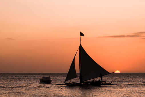 Two Boats and silhouettes and sunset.
