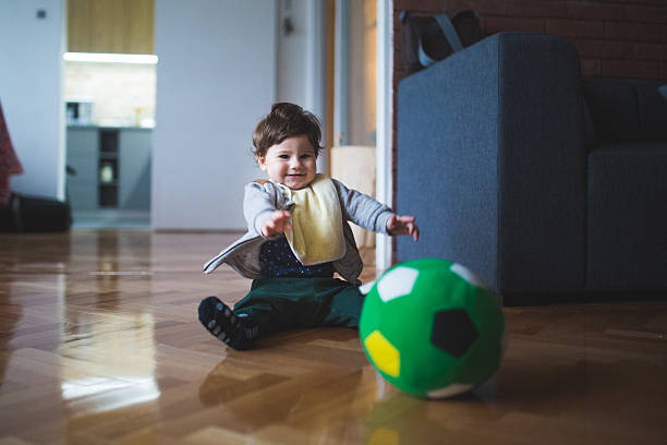 istock Little boy playing with green ball 517844636