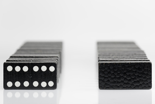 Composition of standing black domino bricks with white dots.