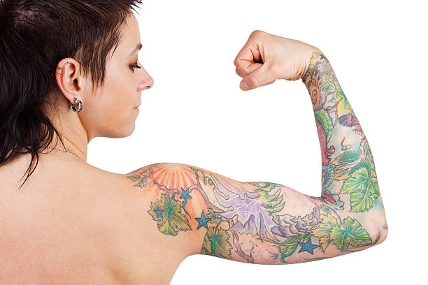 Woman with a tattoo showing biceps Dark-haired woman with a tattoo showing biceps forearm stock pictures, royalty-free photos & images