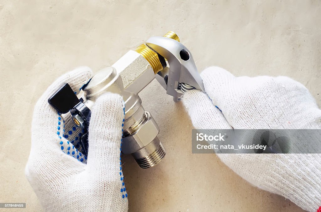 plumber at work with tools plumbing plumber at work with tools plumbing on a light woody background. tinting. selective focus Adjustable Wrench Stock Photo