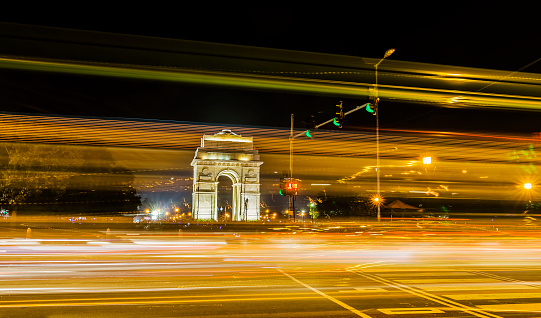 A wide angle long exposure shot of India Gate (formerly known as the All India War Memorial) with light trails of moving vehicles at Rajpath road, New Delhi, India.