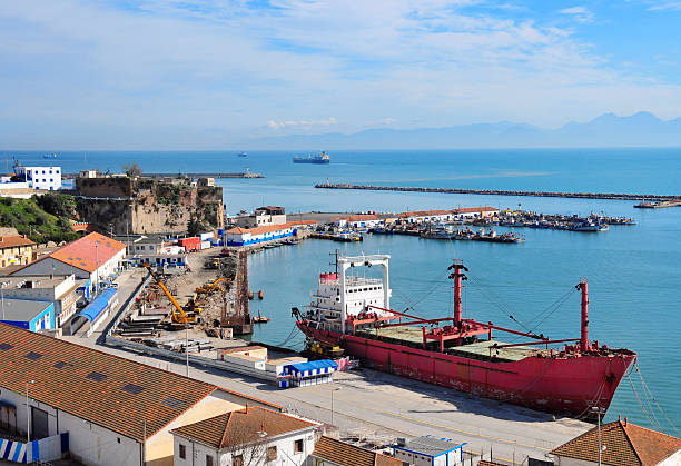 Béjaïa, Algeria: old harbour Béjaïa / Bougie, Kabylia, Algeria: Sidi Abdelkader fort, old harbour, warehouses and freighter - ships on the horizon,  Gulf of Bejaia - photo by M.Torres kabylie stock pictures, royalty-free photos & images